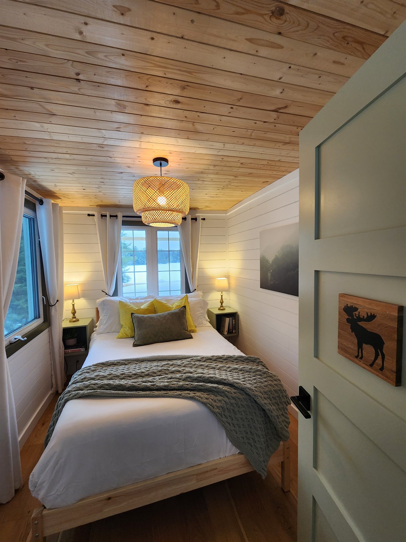 Queen bedroom with white walls and pine ceiling